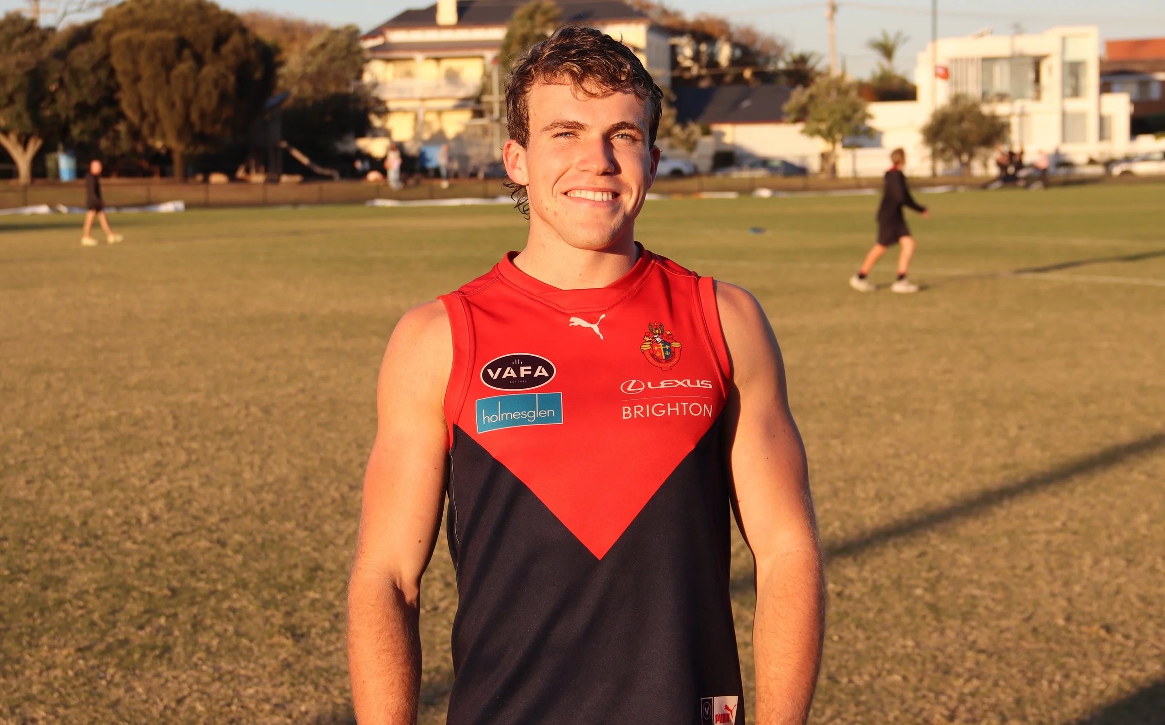 An Old Brighton men's player smiling on the ground at training