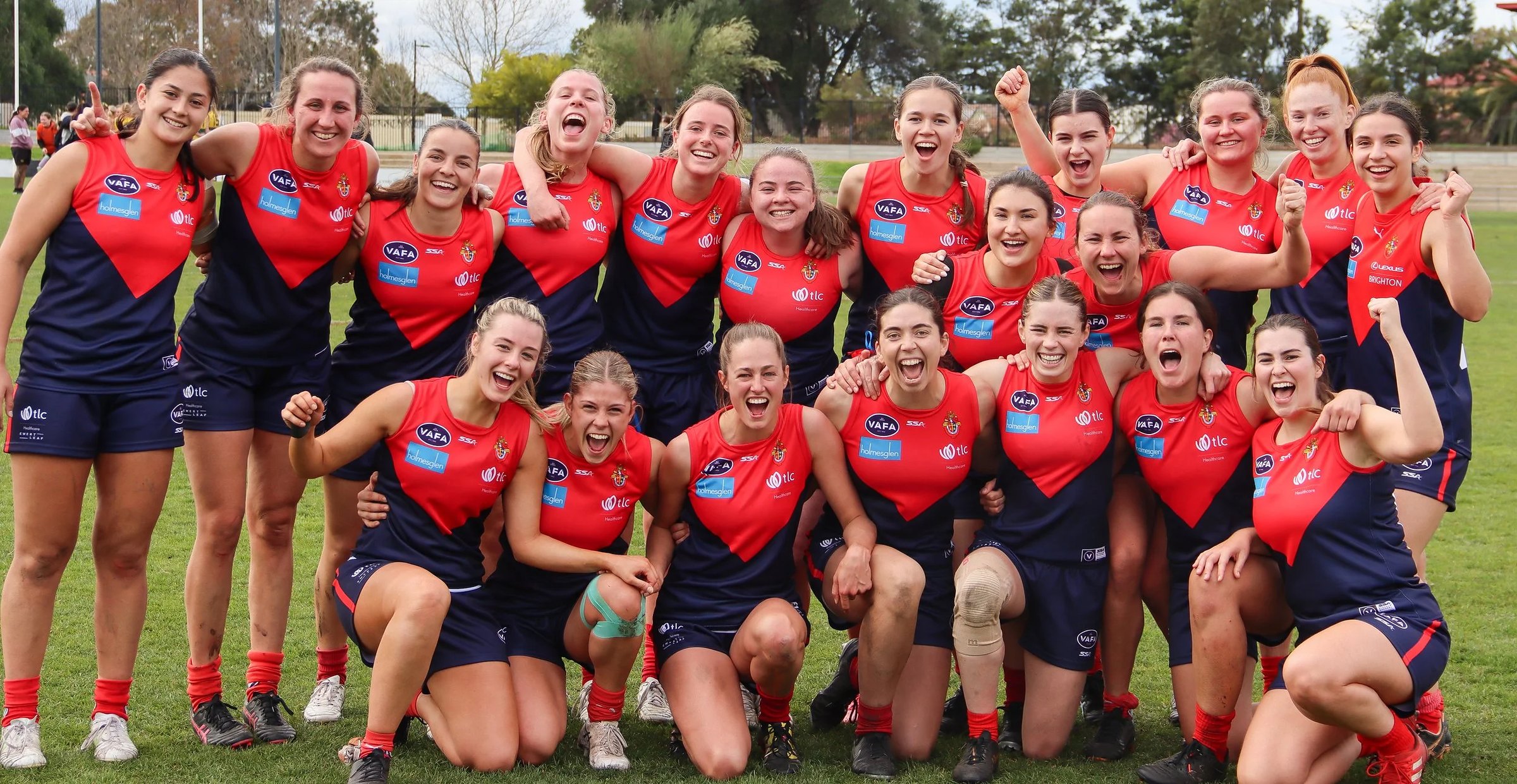 The Old Brighton women's team celebrating together on the ground