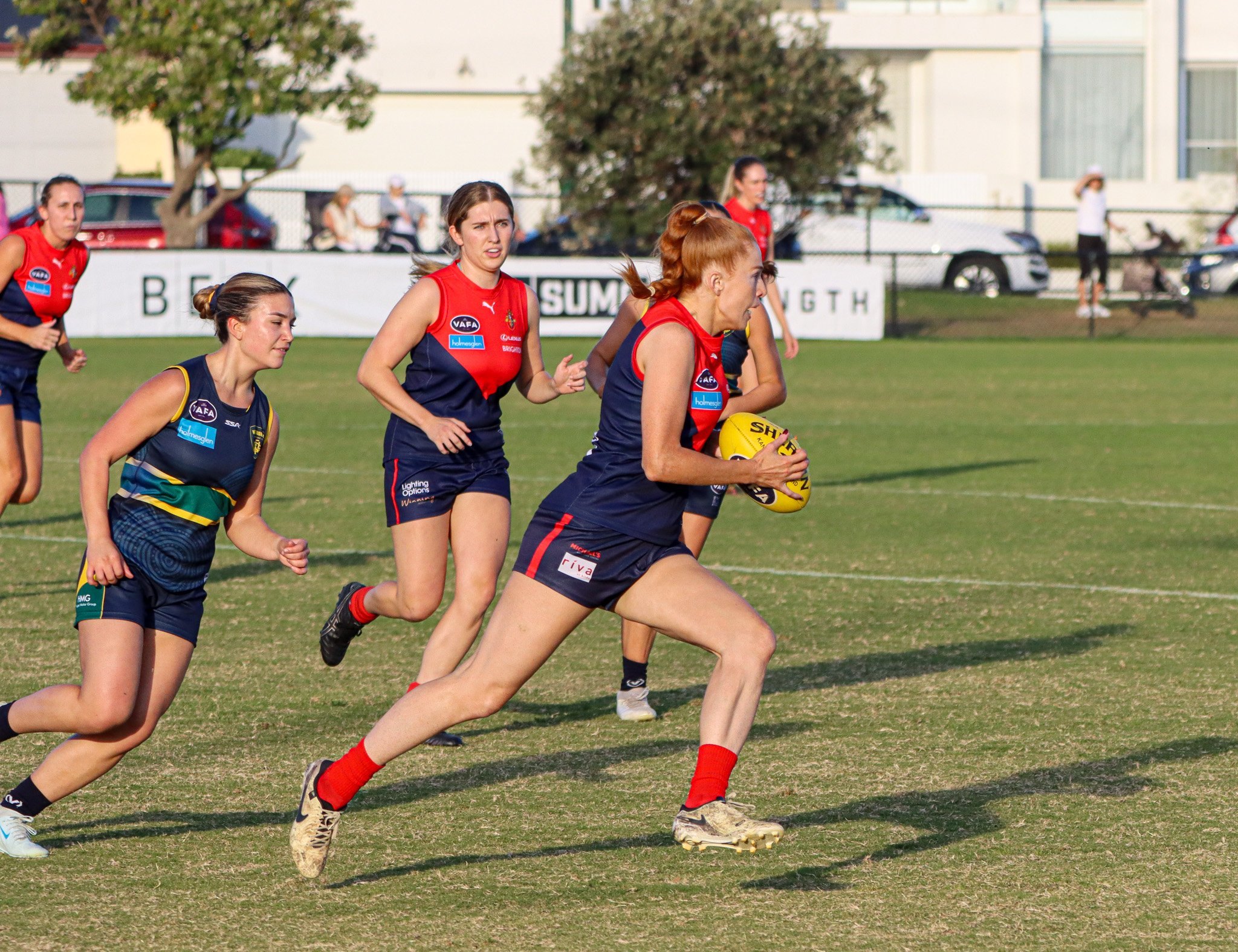 An Old Brighton women's player running with the ball